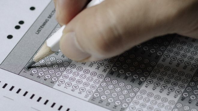 a hand holding a pencil to a multiple choice page