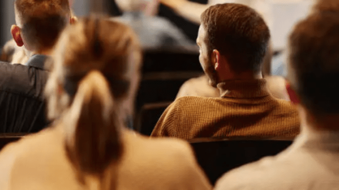 a closeup of the heads and backs of several people in warm tones