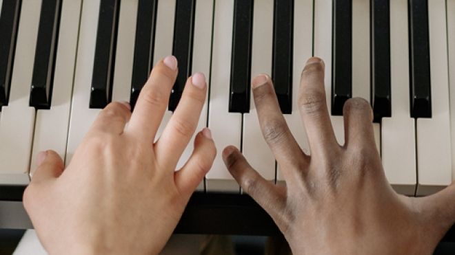 Two sets of hands on piano keys