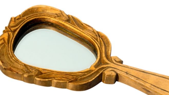 gold-framed hand mirror on a white background