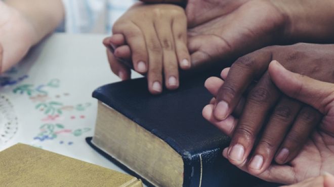 sets of hands on a prayer book
