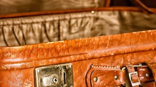 close-up of a tan suitcase, opened to show silk interior