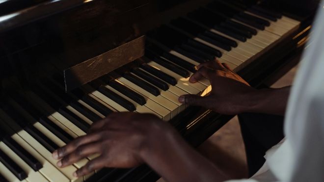 two black hands on a piano