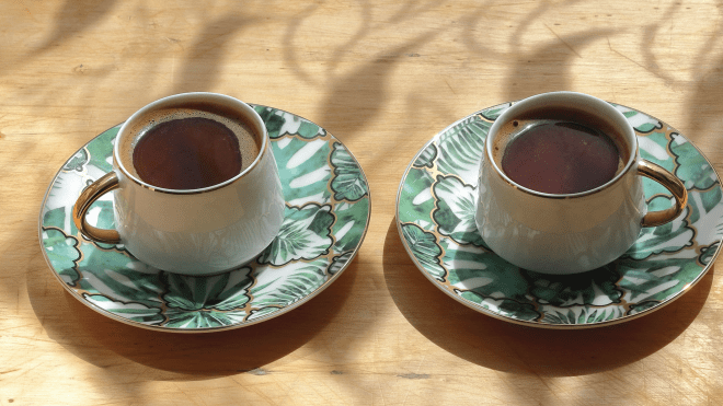two green teacups on a wood table