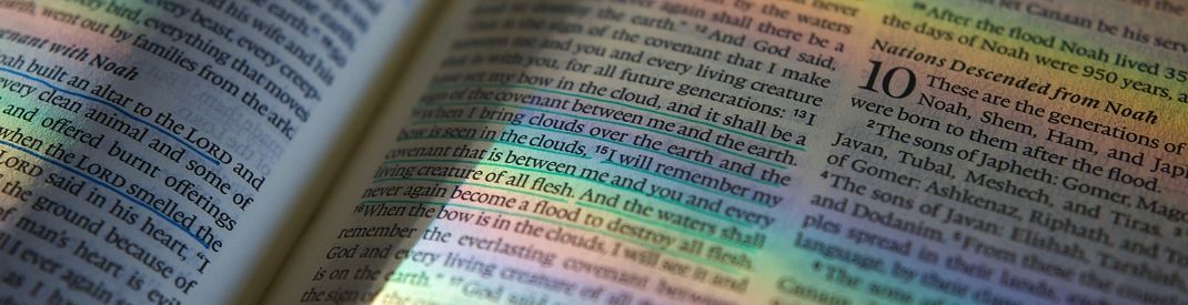 Open Bible with rainbow colours across the page