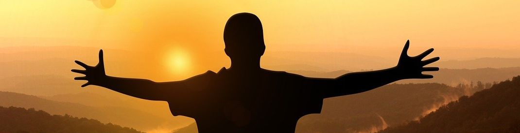 Precious Lord, God of Creation Person with arms outstretched facing an orange sky