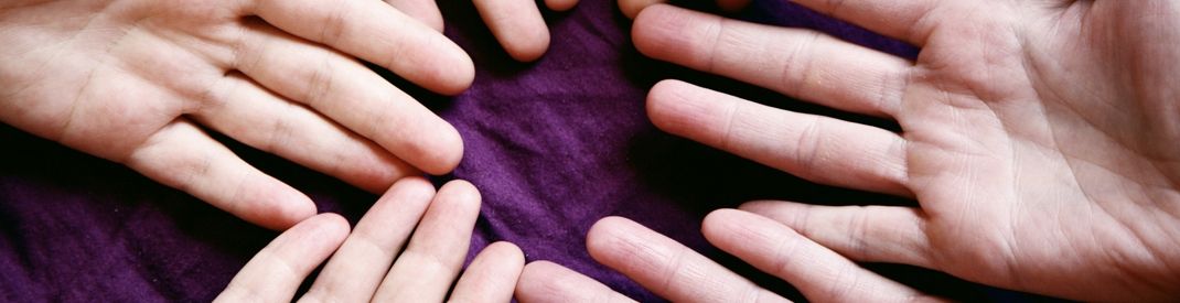 open hands in a circle on a purple cloth