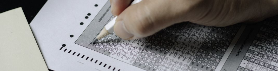 a hand holding a pencil to a multiple choice page