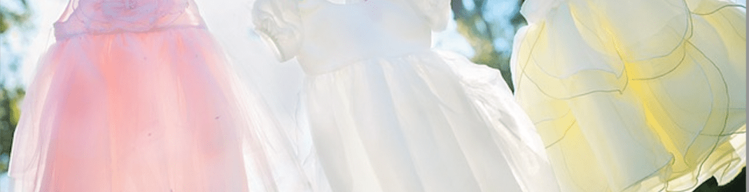 three children's summer dresses on a clotheline