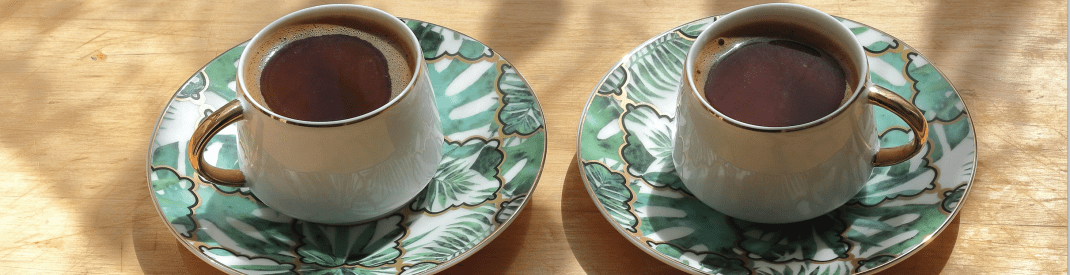 two green teacups on a wood table
